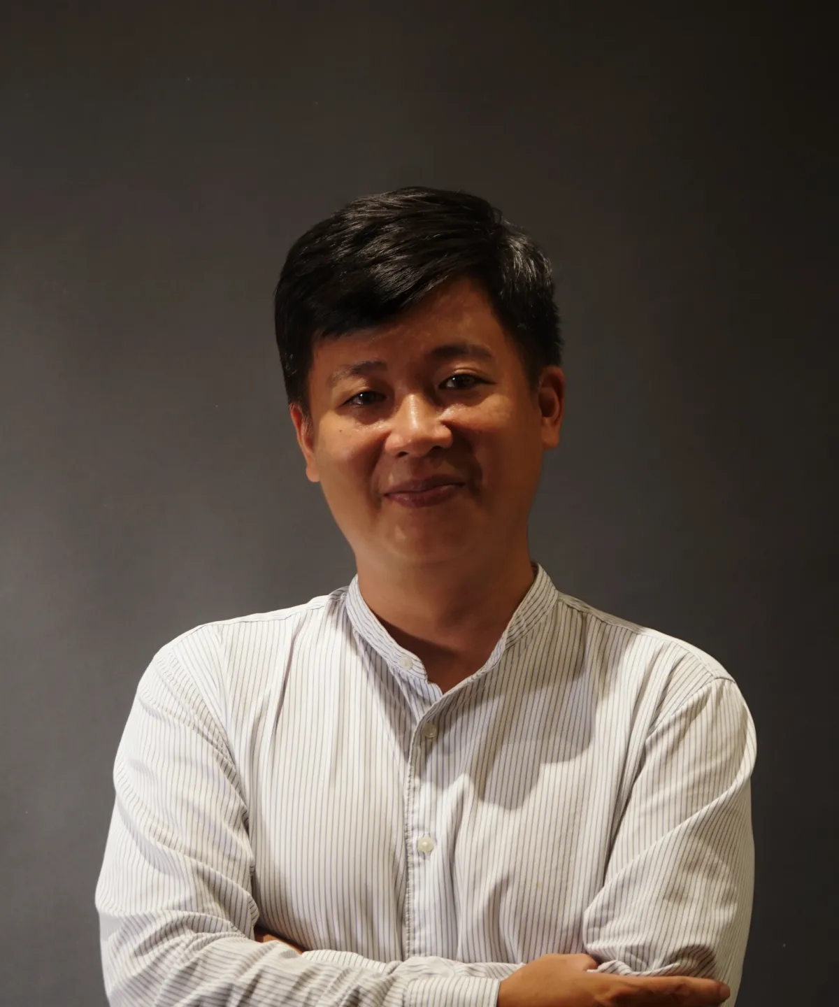 Profile portrait of a man in a white shirt against a light background