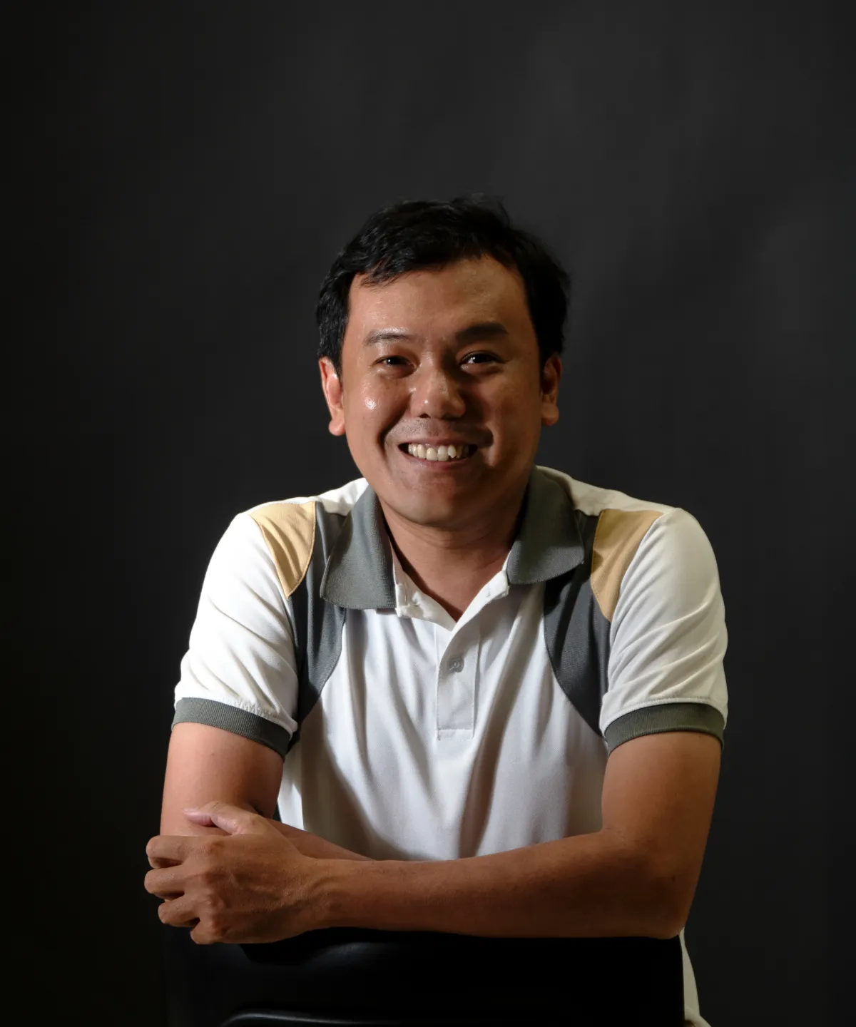 Profile portrait of a man in a white shirt against a light background